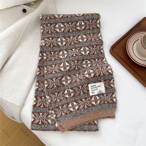 Détail d'une écharpe en maille d'hiver avec motifs géométriques et étiquette rétro en tissu