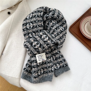 Détail d'une écharpe en maille avec motif jacquard vintage et étiquette tissée