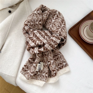 Gros plan d'une écharpe en tricot avec motif jacquard rétro marron et blanc à flocons