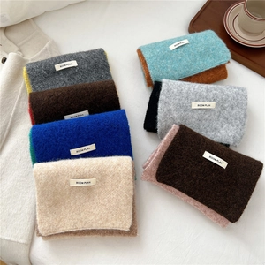 Detailed knit texture of cozy scarves in various colors with woven BOOM PLAN label