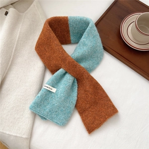 Detailed knit texture of orange and light blue color-block winter scarf with woven label