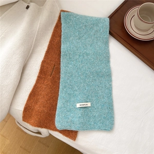 Detail of blue and brown knitted scarf with a soft wool texture and cross-over slit design