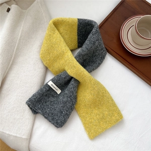 Close-up of yellow and gray knit scarf with woven Boom Plan label and thick texture