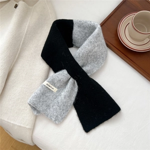 Detail of grey knit scarf with BOOM PLAN label and soft winter aesthetic textures