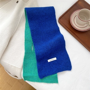 Detail of blue and green two-tone knitted scarf with BOOM PLAN brand label