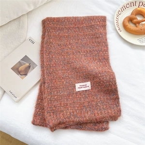 Dettaglio di sciarpa in maglia a quadri con trama vintage ed etichetta fatta a mano