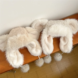 Plush earflap trapper hats with pom-poms in beige and white for winter warmth