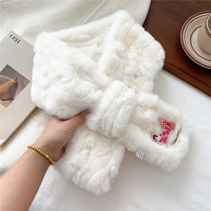 Close-up of white plush scarf featuring cute puppy embroidery and red plaid bow detail