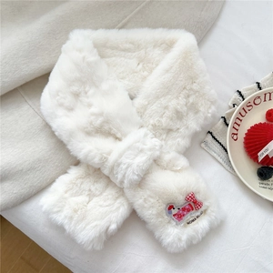 Detail of white faux fur winter scarf with embroidered bow and red checkered pattern