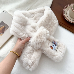 Detail of plush faux fur scarf with cute dog embroidery and stylish criss-cross design