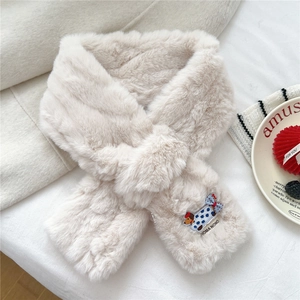 Detail of embroidered cartoon puppy patch on plush cream faux fur winter scarf