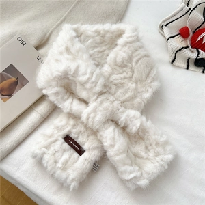 Detail of creamy white faux fur scarf showing cross-over design and brand woven label