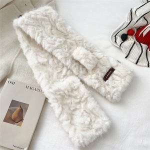 Detailed view of cream faux fur scarf with cross buckle design and leather label