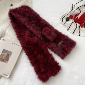 Close-up of fluffy wine red faux fur scarf texture with a woven brand logo label