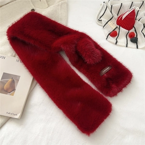 Detail shot of the plush red faux fur texture and branded label on a cross scarf