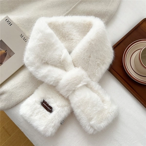 Detail of white faux fur scarf with soft plush texture and elegant cross-over design
