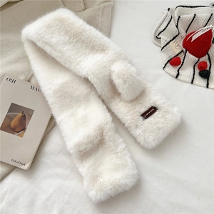 Detail of white faux fur scarf with leather logo tag and soft plush texture