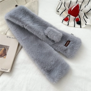 Detail of light grey faux fox fur scarf with cross-over slit and premium leather logo tag