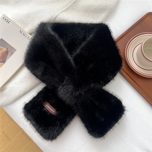 Detail of soft black faux fur scarf with leather brand label on elegant lifestyle setting