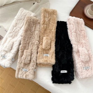Detailed close-up of thick striped faux fur scarves in five neutral colors with brand labels