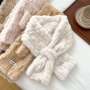 Detailed view of plush cross mufflers in cream, pink, and camel on a soft background
