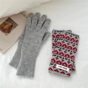 Detail of grey knitted winter gloves and jacquard arm warmers with geometric patterns