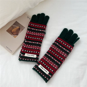 Detail of vintage Fair Isle knit pattern and texture on green woolen winter gloves