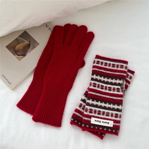 Detail of red knit gloves and patterned fingerless wrist warmers with ribbed cuffs