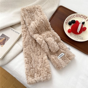 Detailed texture of thick plush faux fur scarf in warm almond with brand woven label