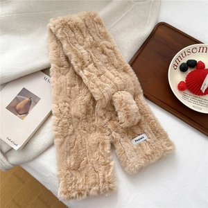 Detail of camel plush scarf showing ribbed texture and brand label on soft fabric
