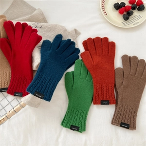 Flat lay of colorful 100% wool knitted gloves with stylish cable knit cuff details