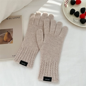 Detailed view of beige 100% wool knitted gloves featuring a classic cable knit pattern