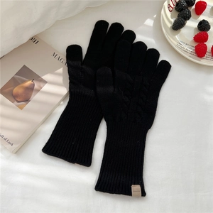 Detail of 100% wool knit gloves with classic cable pattern and warm long cuffs