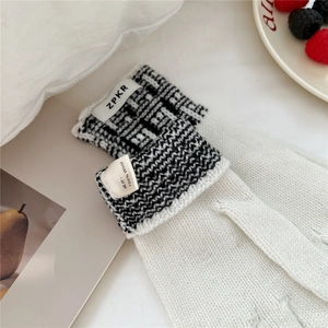 Gros plan de gants en tricot 100% laine avec poignets en jacquard géométrique bicolore