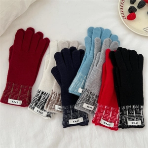 Vue détaillée de gants en tricot avec motifs jacquard à carreaux et écussons de logo