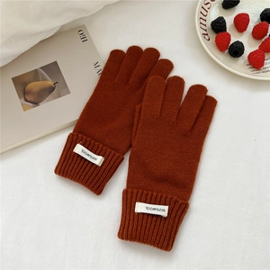 Detailed view of caramel wool gloves with 100% wool label on warm ribbed cuff finish