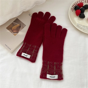 Gros plan de gants tricotés rouges avec poignets à motifs et étiquettes tissées