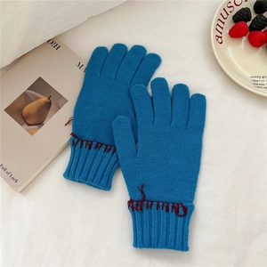 Close-up of dark blue knit gloves featuring red hand-stitched details and ribbed cuffs