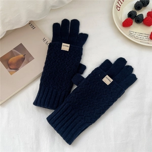 Detail of navy blue knitted gloves with diamond pattern and fold-over finger covers