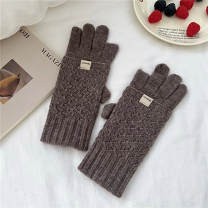 Detailed view of dark brown diamond-knit gloves on textured white fabric background