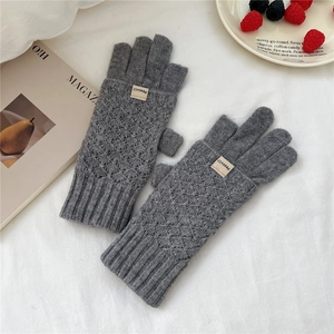 Detailed view of dark grey knitted gloves with diamond pattern and ribbed wrist cuff