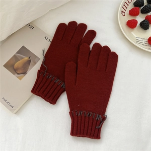 Detail of dark red knit gloves with contrast grey stitching and ribbed elastic cuffs