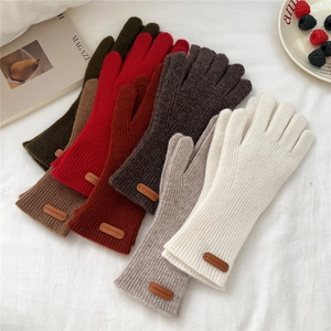 Détails des gants en tricot d'hiver avec poignets côtelés et petites étiquettes en cuir pur