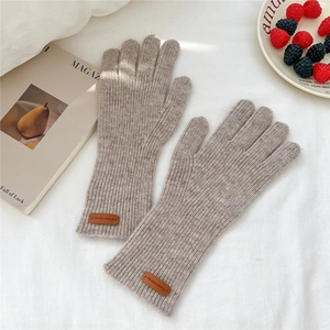 Détails du tricot gris chiné des gants en laine avec étiquette en cuir embossé