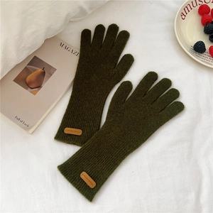 Détail de la maille des gants d'hiver vert olive avec écusson en cuir élégant