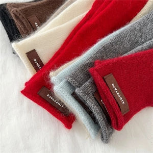 Macro view of assorted knitted textures showing soft wool blend and brand leather labels