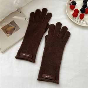 Detailed view of dark coffee knitted wool gloves with elastic wrist and leather brand tag