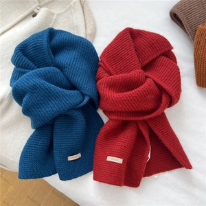 Solid color wool knit scarves in navy and red with leather brand label for winter warmth