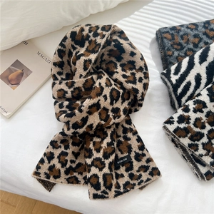 Chic leopard print wool blend knitted scarf for women on soft white bedding background