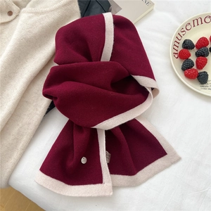Macro detail of wine red and beige knitted wool scarf with delicate ribbed texture